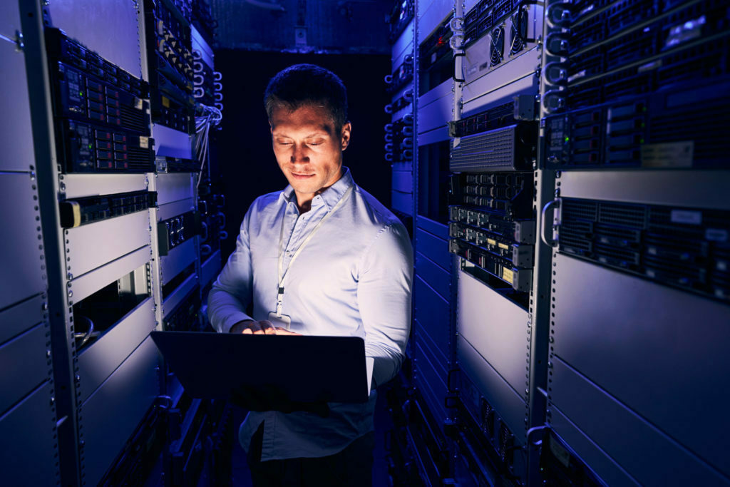 a man sitting at a desk in a server room