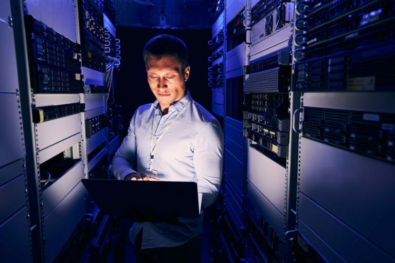 a man sitting at a desk in a server room