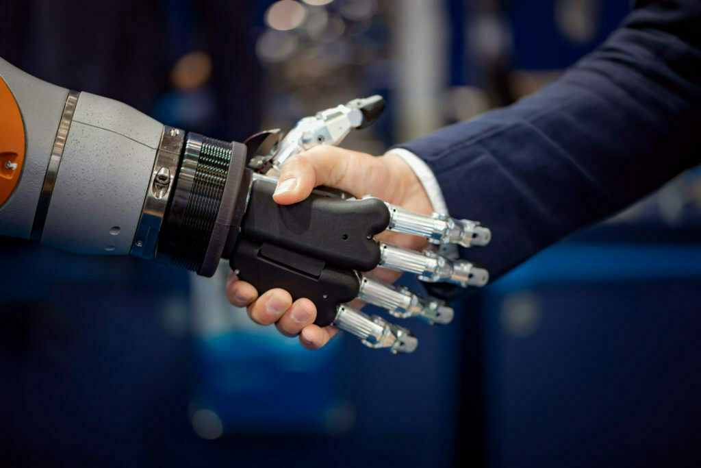 Hand of a businessman shaking hands with a Android robot