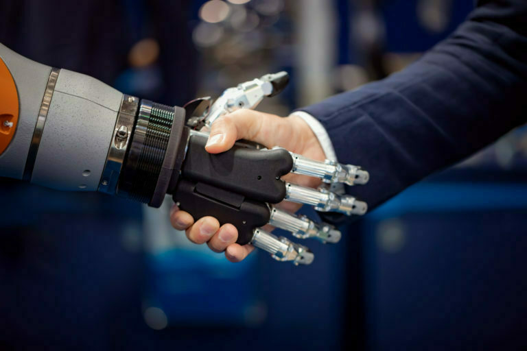 Hand of a businessman shaking hands with a Android robot